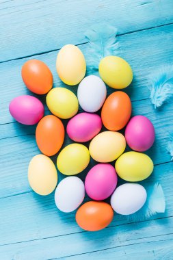 Ahşap masa üzerinde pastel renklerde Paskalya yumurtaları