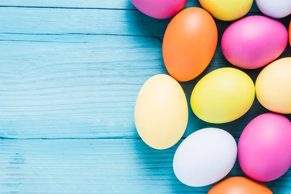 Ahşap masa üzerinde pastel renklerde Paskalya yumurtaları