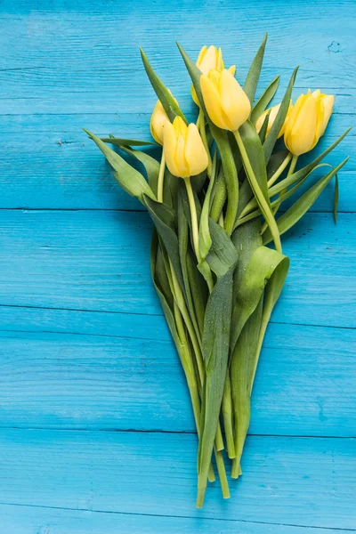 Bunch of fresh tulips on vibrant table — Stock Photo, Image