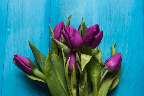 Bando de tulipas frescas na mesa vibrante — Fotografia de Stock