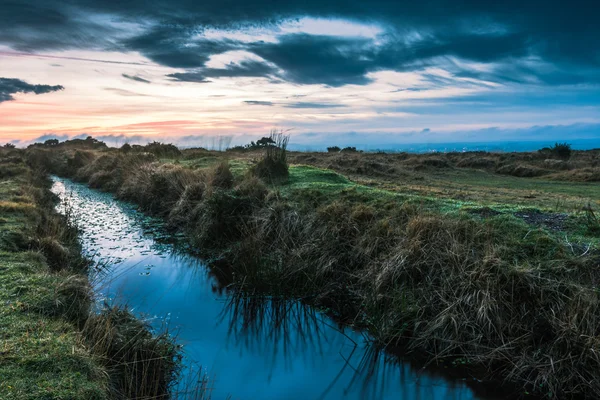 Dramatic sunset reflect in wild creek water — Stock Photo, Image