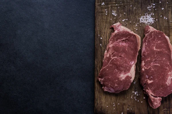 Verse rauwe stirlion rundvlees biefstukken met zout — Stockfoto
