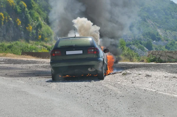 Carro em chamas na estrada — Fotografia de Stock
