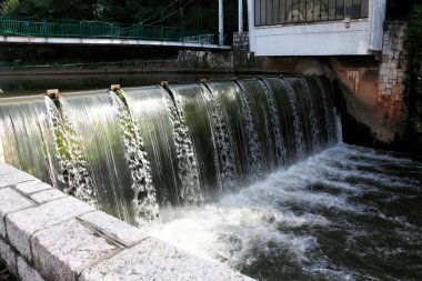 Bosna-Hersek 'in Saraybosna kentindeki Bentbasa manzarası, Miljacka Nehri şelalesi ve yaz yeşillikleriyle çevrili barajı gösteriyor