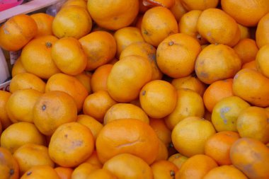 Yerel bir market tezgahında taze mandalina yığını.