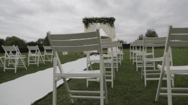 Açık hava düğün töreni süslemesi ama insan yok. Düğün hazırlıkları ve düğün töreni için düğün sandalyeleri. 4K