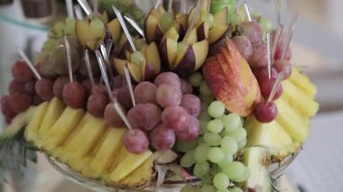 Açık büfe masasındaki meyve tabağının yakın çekimi. Her şey uyumlu ve düzenli görünüyor. Yavaşça.