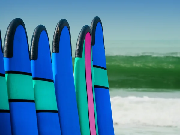 Tablas de surf de color en una pila por océano —  Fotos de Stock