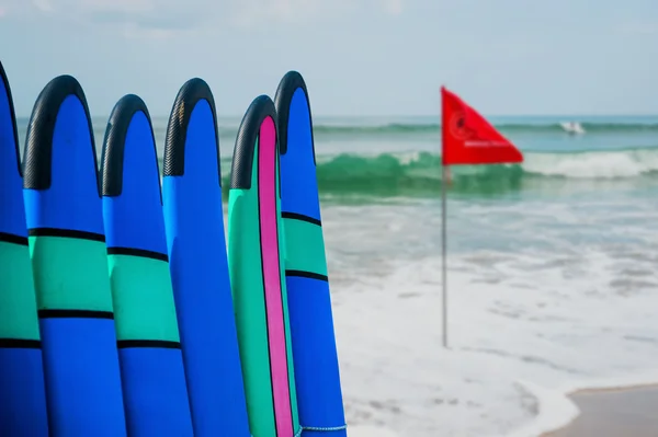 Color surf boards in a stack by ocean — Stock Photo, Image