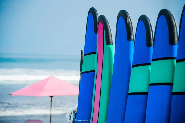 Color surf boards in a stack by ocean — Stock Photo, Image