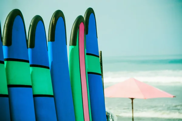 Farbige Surfbretter in einem Stapel am Meer — Stockfoto