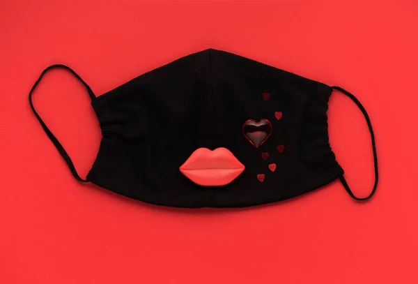 Red heart and lips with medical protective mask on red background, top view, flat lay. Creative Concept love, valentine \'day, healthcare, protection