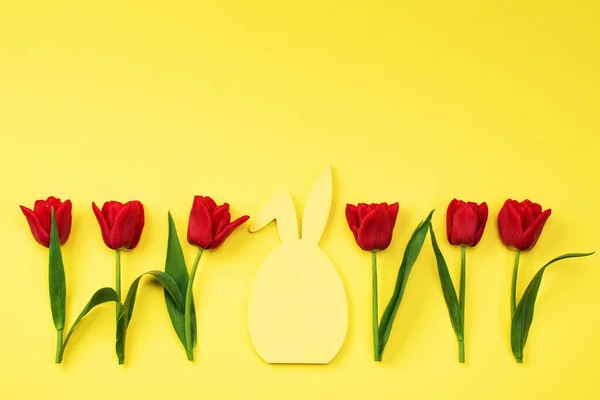 Tulips red on a yellow background and chalk board