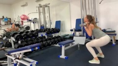 Spor salonunda egzersiz yapan ince kaslı bir kız. Akşamları spor salonunda çalışıyorum..