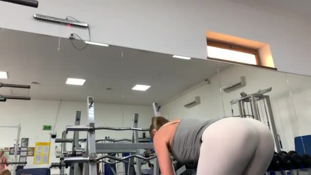 一个身材苗条的肌肉发达的女孩在体育馆里做运动 晚上在体育馆里锻炼 — 图库视频影像
