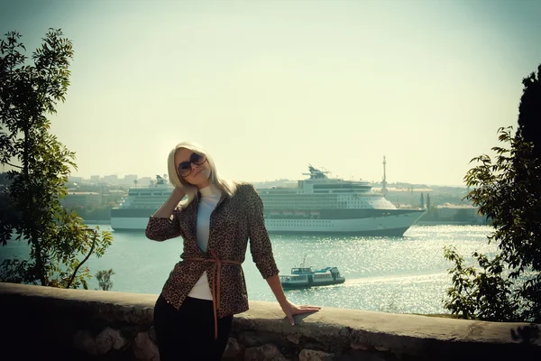 Schöne Blondine auf dem Hintergrund eines Kreuzfahrtschiffes — Stockfoto