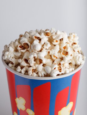 Çıtır çıtır kızarmış patlamış mısır bir gri arka planı kapat-u üzerinde çizgili kutusu