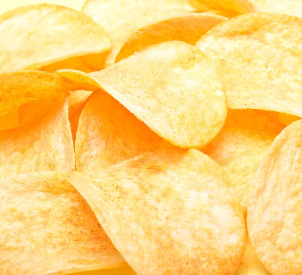 Beautiful golden potato chips as background — Stock Photo, Image