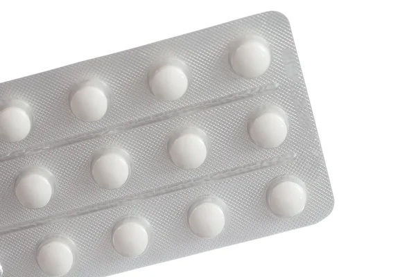 Tablety v balení detail izolovaných na bílém pozadí — Stock fotografie