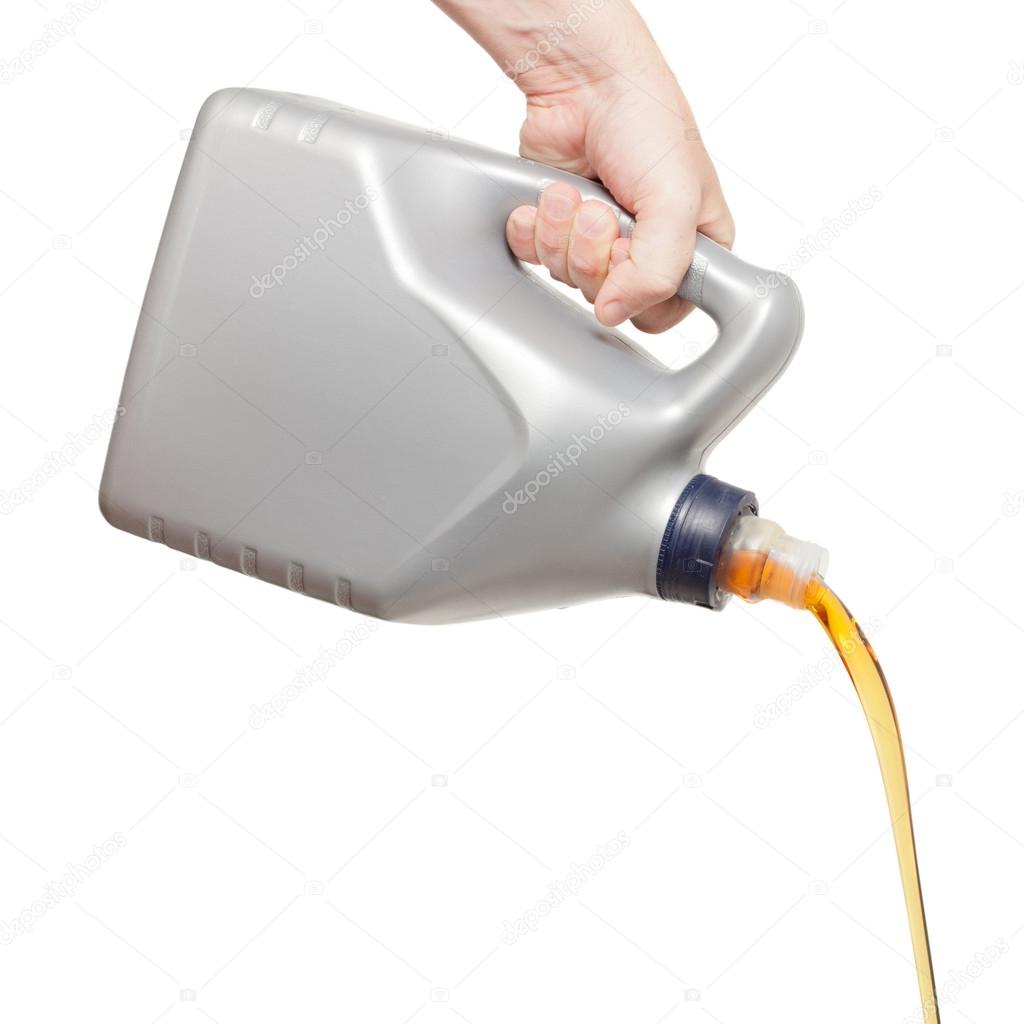 Engine oil pouring from a canister in hand isolated on white bac