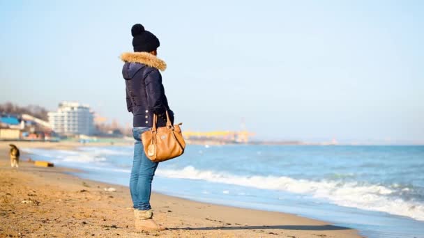 Молодая красивая девушка прогулки в осенний день вдоль берега моря — стоковое видео