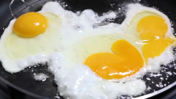 Омлет из трех яиц, поджаренных на сковороде, крупным планом — стоковое видео