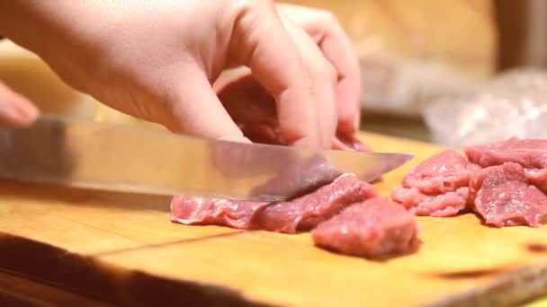 Close-up mulher na cozinha está cortando carne de porco na tábua de corte — Vídeo de Stock