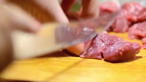 Close-up femme dans la cuisine coupe du porc sur la planche à découper — Video