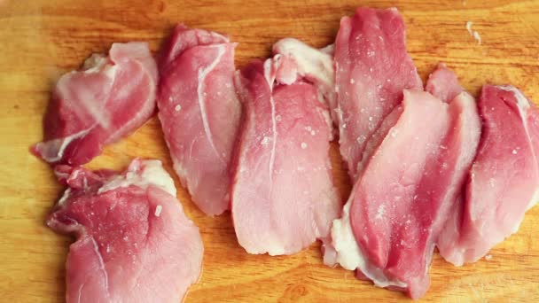 Nahaufnahme Mann in der Küche schneidet Schweinefleisch auf Schneidebrett — Stockvideo