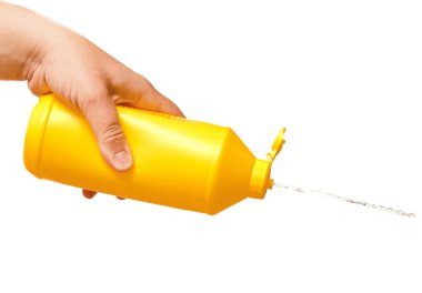 Beyaz arka plan üzerinde izole sarı plastik şişe tutan el