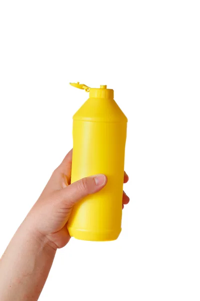 Hand holding yellow plastic bottle isolated on white background — Stock Photo, Image