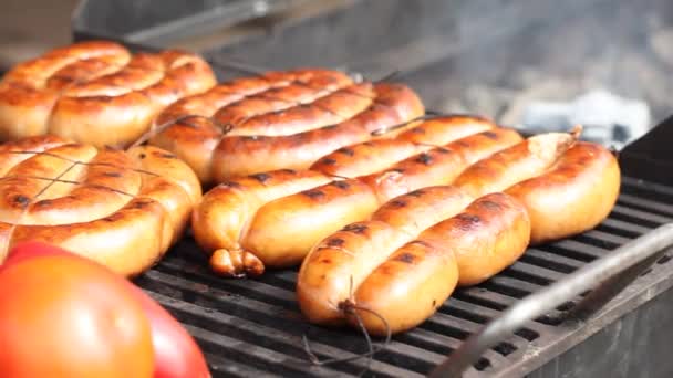 Sausages on grills fried with tomatoes — Stock Video