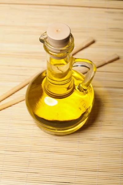 Olive oil and sticks on the wooden background — Stock Photo, Image
