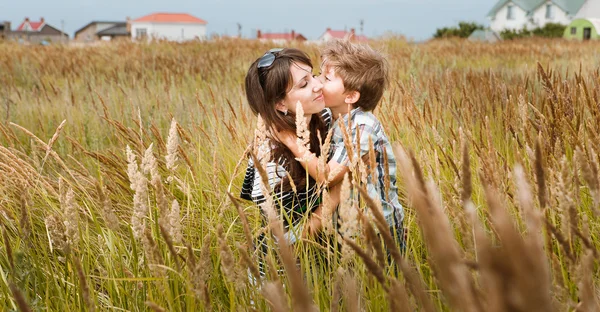 Jonge mooie moeder met zoon plezier op het gazon met gree — Stockfoto