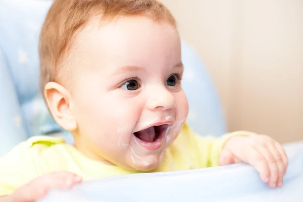 Très petit enfant mange frais savoureux caillés nutritifs sur chaise haute Photos De Stock Libres De Droits