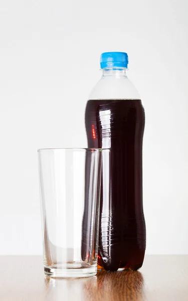 Água fria em garrafa de plástico transparente com tampa azul e um copo — Fotografia de Stock