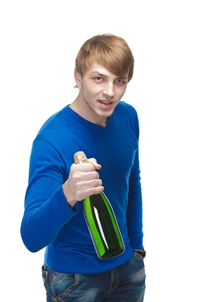 Young man with a bottle of champagne in a blue sweater. Isolated — Stock Photo, Image
