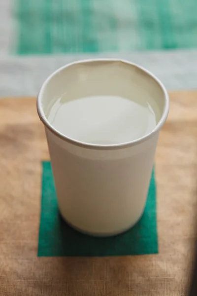 Papier beker een witte kleur, op tafel op de lichte achtergrond — Stockfoto