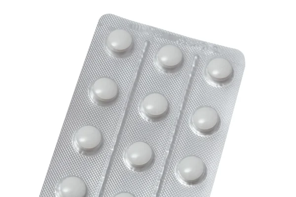 Таблетки в упаковке крупным планом на белом фоне — стоковое фото