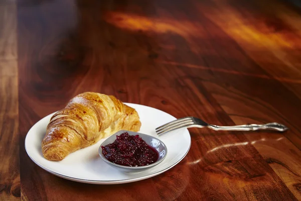 Croissants with jam on white plate — Stock Photo, Image