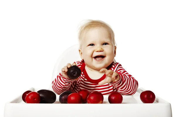 Bebê está selecionando ameixas — Fotografia de Stock