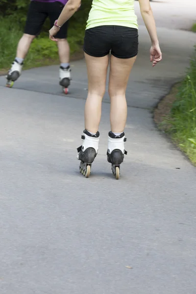 Piernas de la chica montando patines de ruedas — Foto de Stock