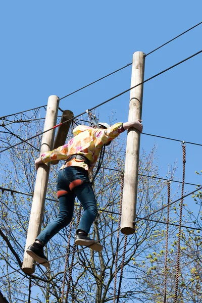 The girl climbs obstacles of rope park — Stock Photo, Image