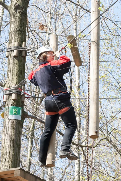 Dziewczyna wspina się przeszkód park linowy — Zdjęcie stockowe