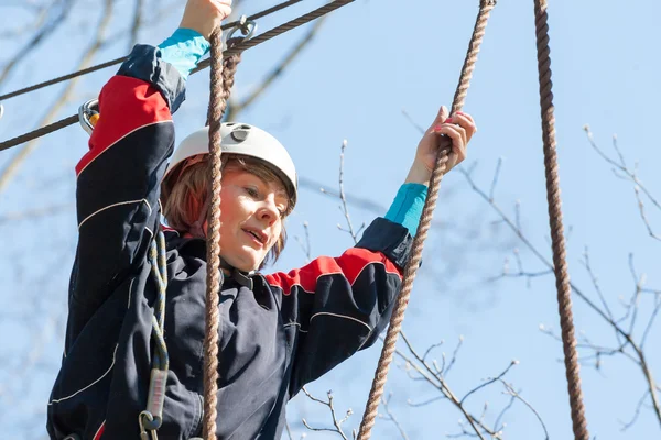 Dziewczyna wspina się przeszkód park linowy — Zdjęcie stockowe