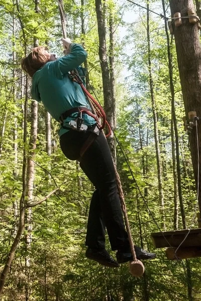 Dziewczyna wspina się przeszkód park linowy — Zdjęcie stockowe