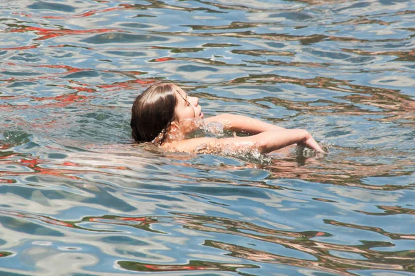 Mujer joven nadando en el océano — Foto de Stock