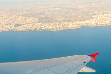 Açık bir yaz gününde bir uçağın kanadından Antalya sahili manzarası
