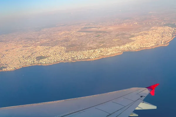 Açık bir yaz gününde bir uçağın kanadından Antalya sahili manzarası