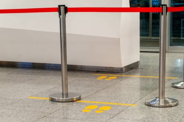 Kırmızı bantlı raflar, fayanslı zemindeki trafiği engelliyor.